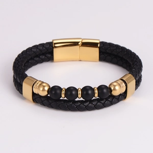 Detail of men's braided leather bracelet with black matte beads and gold magnetic clasp