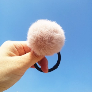 Close-up of fluffy pink faux fur pom pom hair tie with high-elastic black rubber band