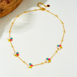 Detailed close-up of gold plated chain necklace with colorful enamel floral charms