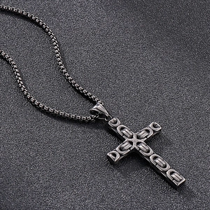 Vue détaillée du pendentif croix en acier inoxydable foncé avec motif chaîne en relief