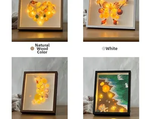 Detail of four DIY shadow box frames with glowing sea shells and stars on a desk