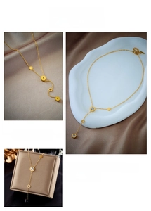 Detail of 18K gold Y-shaped tassel necklace with Roman numeral engraved crystal rings