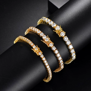 Three gold tennis bracelets with white zircon stones in different widths on black base