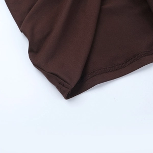 Makrodetail der feinen Nähte und Stricktextur an den Ärmeln des dunkelbraunen Kleides