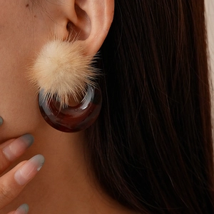 Vintage resin hoop earrings with beige pompom and amber resin circle on model