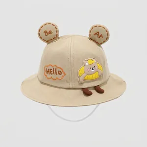 Detail of khaki cotton bucket hat with bear ears, HELLO patch and windproof strap