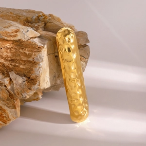 Eleganter goldener Haarclip aus Edelstahl mit Hammerschlag-Optik auf Naturstein