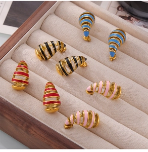 Macro shot of colorful enamel spiral stud earrings in a wooden jewelry display case
