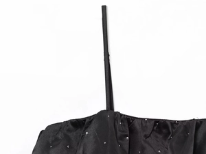 Gros plan sur le tissu en satin noir orné de détails scintillants en strass