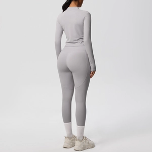 Détail d'un ensemble de yoga gris clair montrant le pantalon taille haute et le haut ajusté