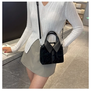 Detail of black crossbody bag with shirt collar design and detachable shoulder strap