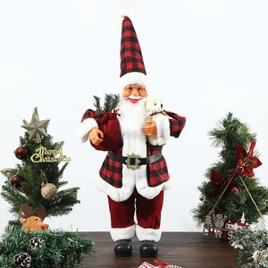Detailed Santa Claus doll with red plaid hat holding white bear and gift bag on wood surface