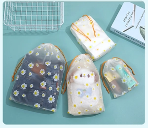 Detail of frosted EVA drawstring bags with white daisy patterns for travel storage