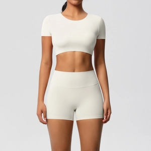 Detail von elfenbeinfarbenem Yoga-Set mit Kurzarm-Crop-Top und High-Waist-Sportshorts