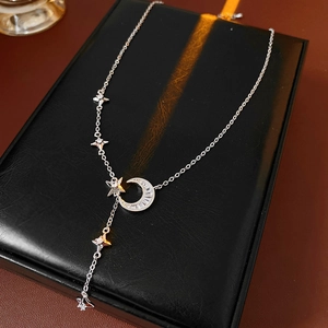 Macro view of silver star and moon pendant necklace with shimmering zircon inlay