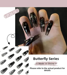 Macro detail of long coffin nails with black gradient, silver butterflies, and rhinestones