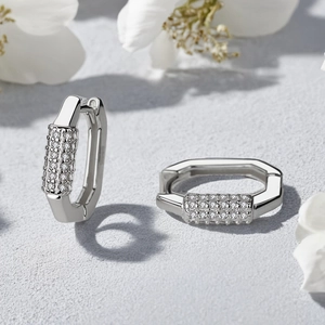 Détail macro de créoles géométriques en argent avec cristaux de zircone micro-pavés