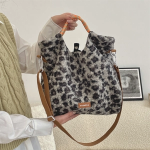 Gros plan du sac en fausse fourrure léopard avec étiquette en cuir et poignée orange