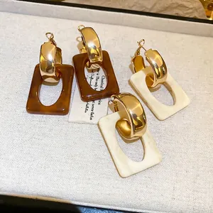 Retro geometric resin earrings set in amber and cream white with gold C-ring hooks