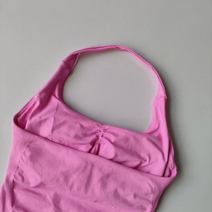 Detailed texture of seamless bright pink halter sports vest with ribbed knit and ruched front