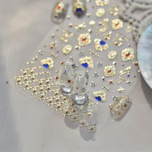 Nahaufnahme goldener geprägter Nagelaufkleber mit blauen Edelsteinen und Vintage-Stil