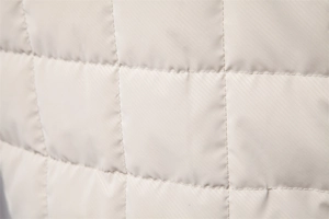 Detailed macro view of square quilted stitching on a men's stand collar beige jacket