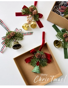 Detail of Christmas bell ornaments with pine cones, ribbons, and needles in a gift box