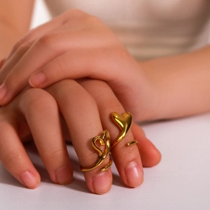 Polished 18k gold plated stainless steel open rings with hollow heart design on a model