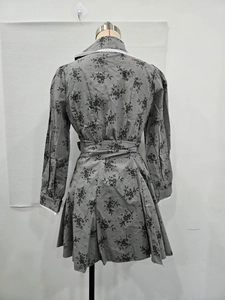 Détail d'une robe grise à fleurs à manches longues avec col classique et dentelle