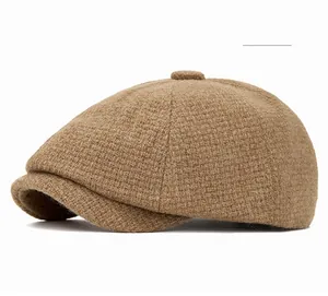 Close-up of khaki tweed fabric texture and button detail on a vintage newsboy cap
