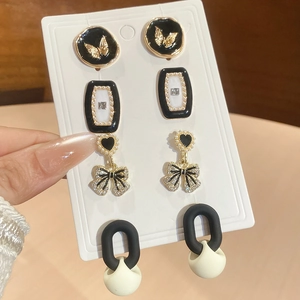 Détail de quatre ensembles de boucles d'oreilles perles vintage avec papillon et cœur noir