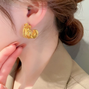 Macro shot of gold-plated multi-layer C-shape hoop earrings with artistic wire design