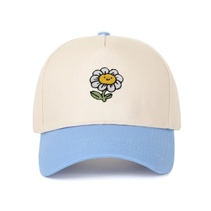 Detail of sunflower smiley face embroidery on a color-block cotton baseball cap