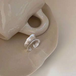 Detail of S925 sterling silver ring with irregular hammered texture on ceramic plate