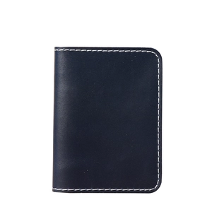 Detail view of navy blue leather card holder with contrast white stitching on white background