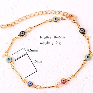 Close-up of gold-plated evil eye bracelet with colorful pendants on a white background
