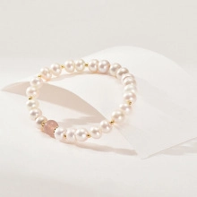 Detailed close-up of natural white freshwater pearls with a pink gemstone accent bead