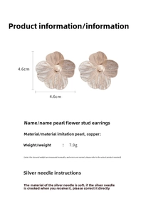Macro shot of 4.6cm metal flower earrings with pearl center and radial texture