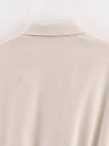 Detail of the stitching and turn-down collar on a beige fashionable bomber jacket