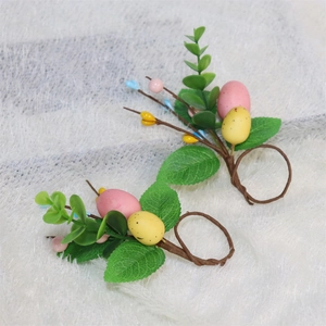 Detail of Easter napkin ring with speckled eggs, green leaves and colorful berries