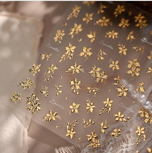 Close-up of gold flower nail stickers with Sunshine script and floral foil patterns