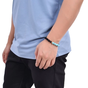 Detail of 10mm faceted turquoise and obsidian beaded bracelet on a model wrist