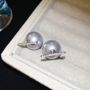 Macro detail of luxury grey pearl earrings with pavé zircon metal bar on velvet box