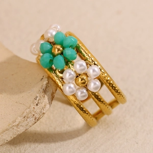 Détail d'une bague en acier inoxydable plaqué or 18K avec fleurs en perles vertes