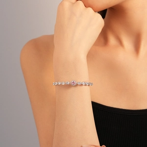 Detail shot of elegant silver bracelet with oval pink gemstone and pear-cut zircons