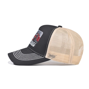 Close-up of trucker hat showing detailed red truck embroidery and white peak stitching