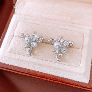 Detail shot of silver floral pearl earrings displayed in a premium jewelry gift box