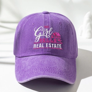 Macro detail of purple washed cotton baseball cap with GIRL SELLS REAL ESTATE embroidery