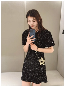 Mini star-shaped metal chain bag paired with a sparkling black sequined mini dress