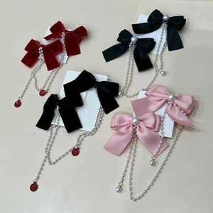Detail of velvet bow hair clips with pearl tassels and lucky Fu character pendants